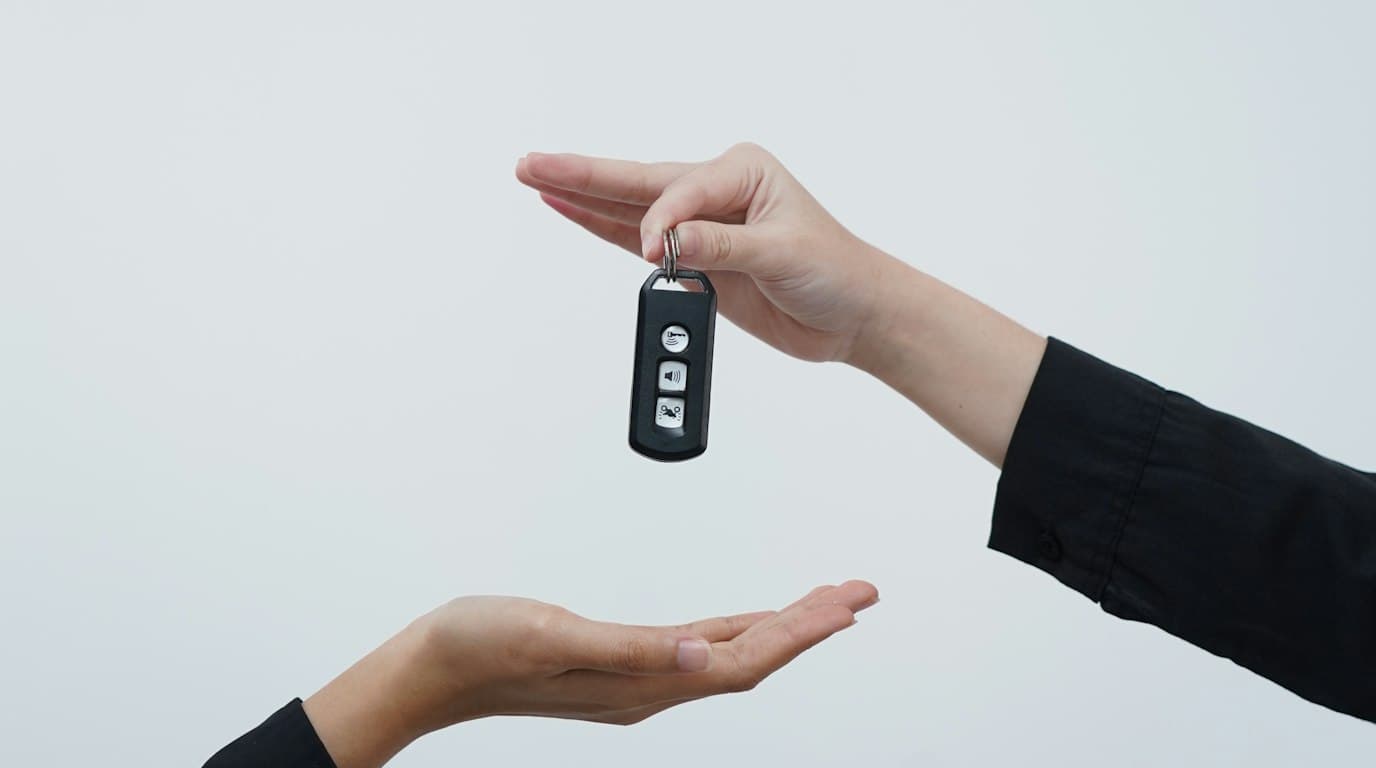 A car key being dropped into an open hand